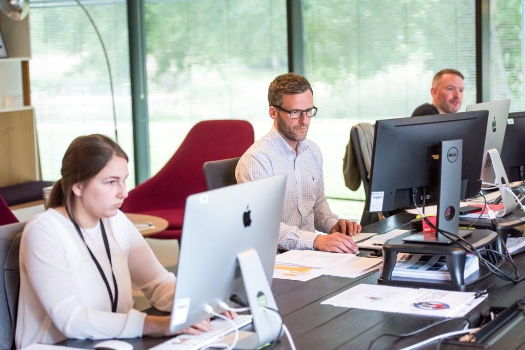 Two people sitting at desks in an office working